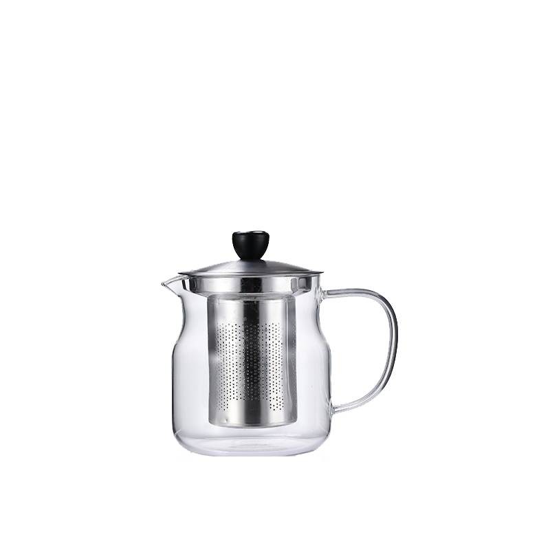 This photograph, taken at a tea table setting, showcases the actual brewing process using a heat-resistant glass teapot. The teapot holds a clear, golden-yellow brew, its built-in stainless steel filter effectively preventing tea leaves from getting insid